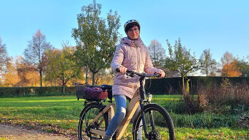 Bettina Hentschel mit ihrem nachhaltigen Holz-Fahrrad bei sonnigem Herbstwetter auf einem Weg Bettina Hentschel mit ihrem nachhaltigen Holz-Fahrrad bei sonnigem Herbstwetter auf einem Weg